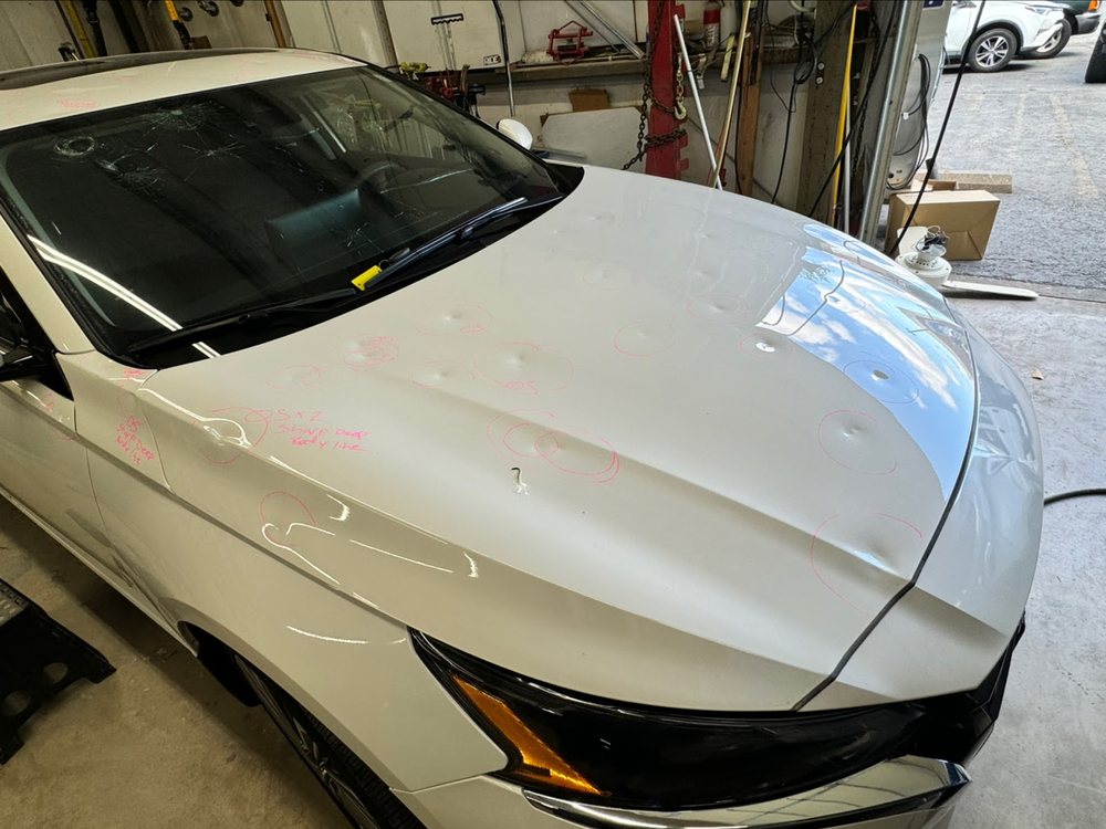 Hail damage on a hood marked out for repair